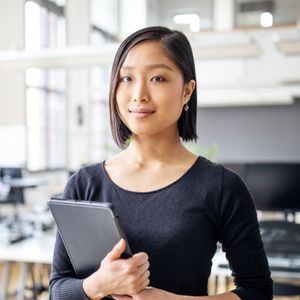 Woman holding a tablet in an office setting.